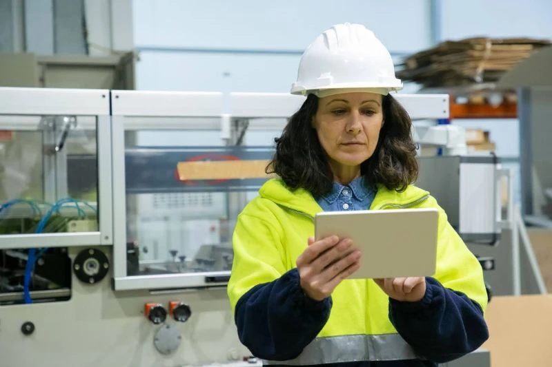 Melhores estratégias para controle de processos industriais Mulher engenheira em indústria revisando informações em um tablet, representando o controle de processos.