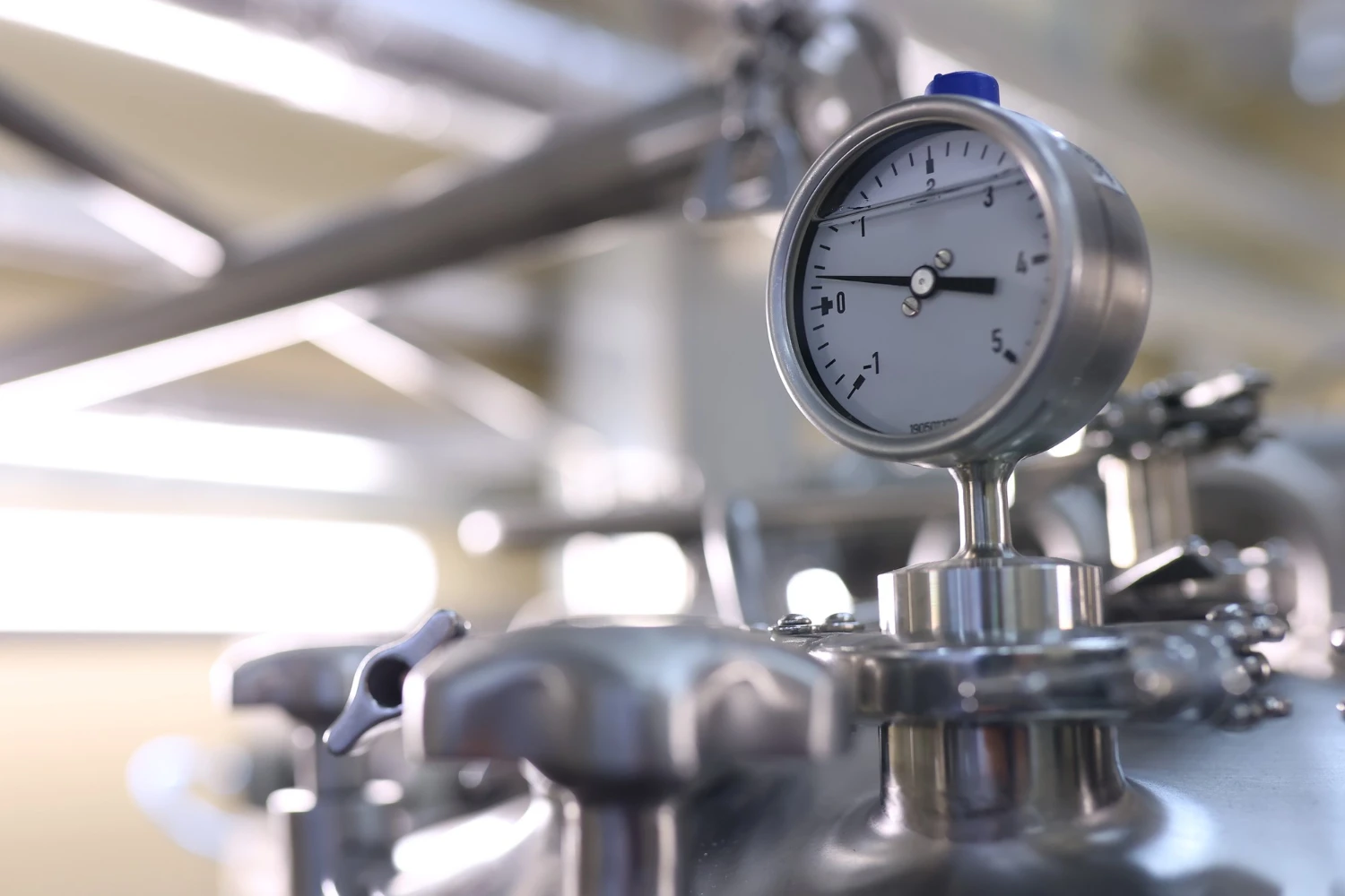Imagem de um manômetro industrial em um equipamento de precisão, utilizado para medir pressão em processos industriais, com foco no mostrador.